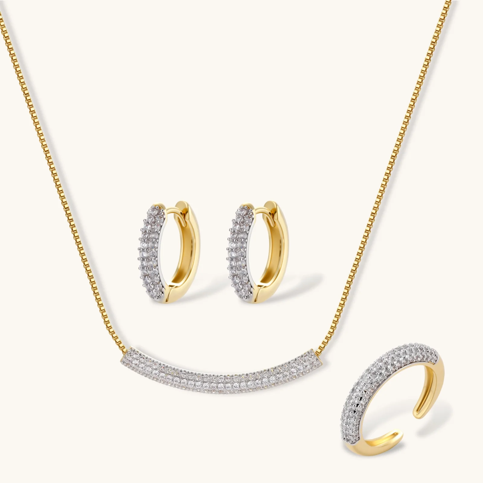 239263700075630592.webp Gold-plated curved necklace, hoop earrings, and adjustable ring with pavé cubic zirconia stones on cream background.