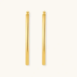 Set of geometric gold-plated sterling silver hoop earrings in oval and cushion shapes on cream background