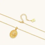 Oval gold coin pendant with pave CZ mandala motif and beaded border on an 18K gold-plated cable chain.