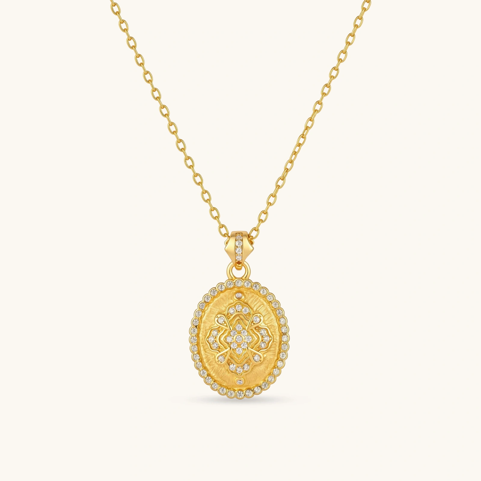 313699226835152896.webp Oval gold coin pendant with pave CZ mandala motif and beaded border on an 18K gold-plated cable chain.
