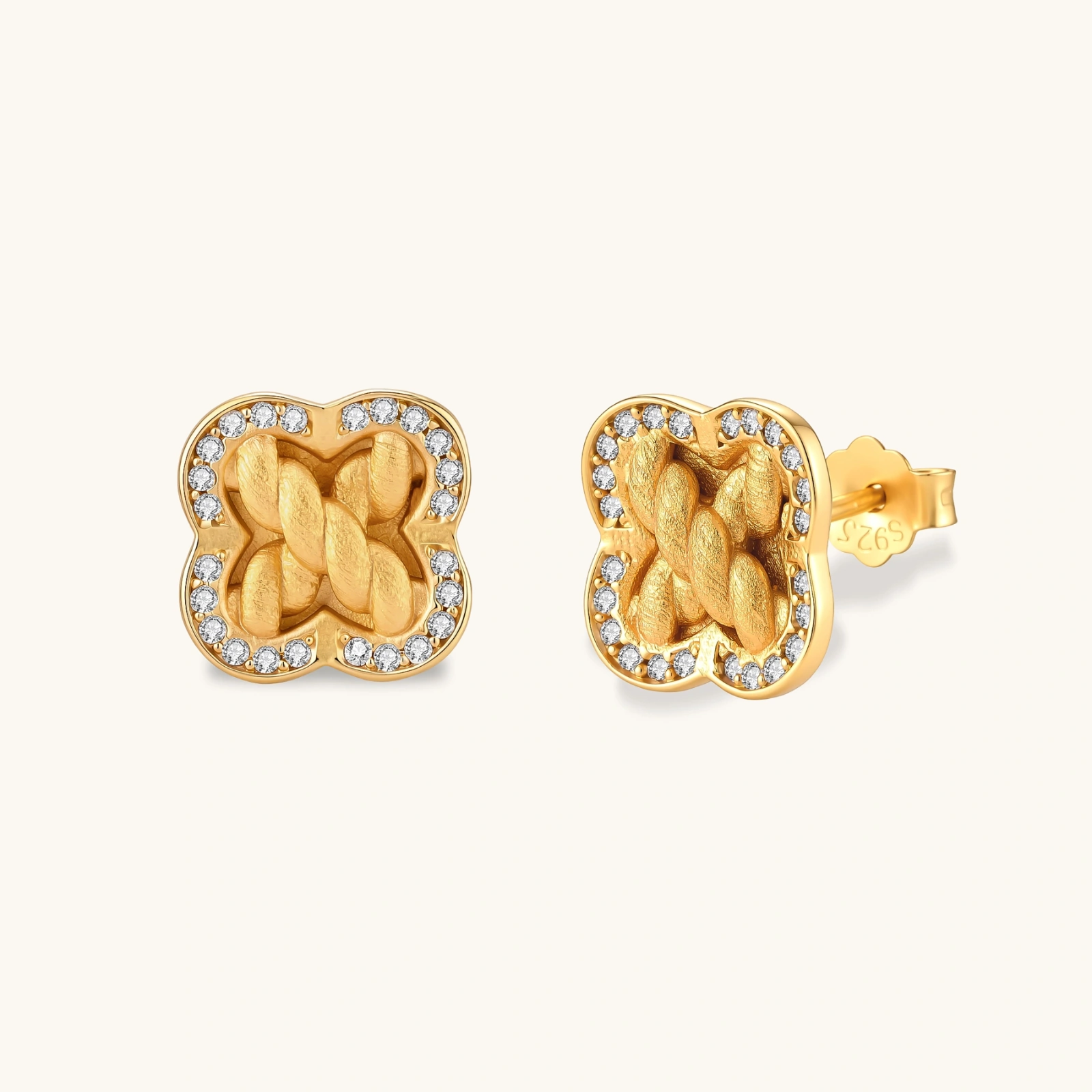 313699713105981440.webp Gold-plated 925 silver clover stud earrings with brushed braid center and CZ stone border, 12mm, push-back closure.