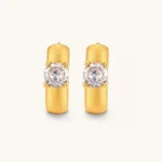 18K gold-plated 925 silver huggie hoops with brushed finish and prong-set round CZ solitaire, stamped S925 inside.